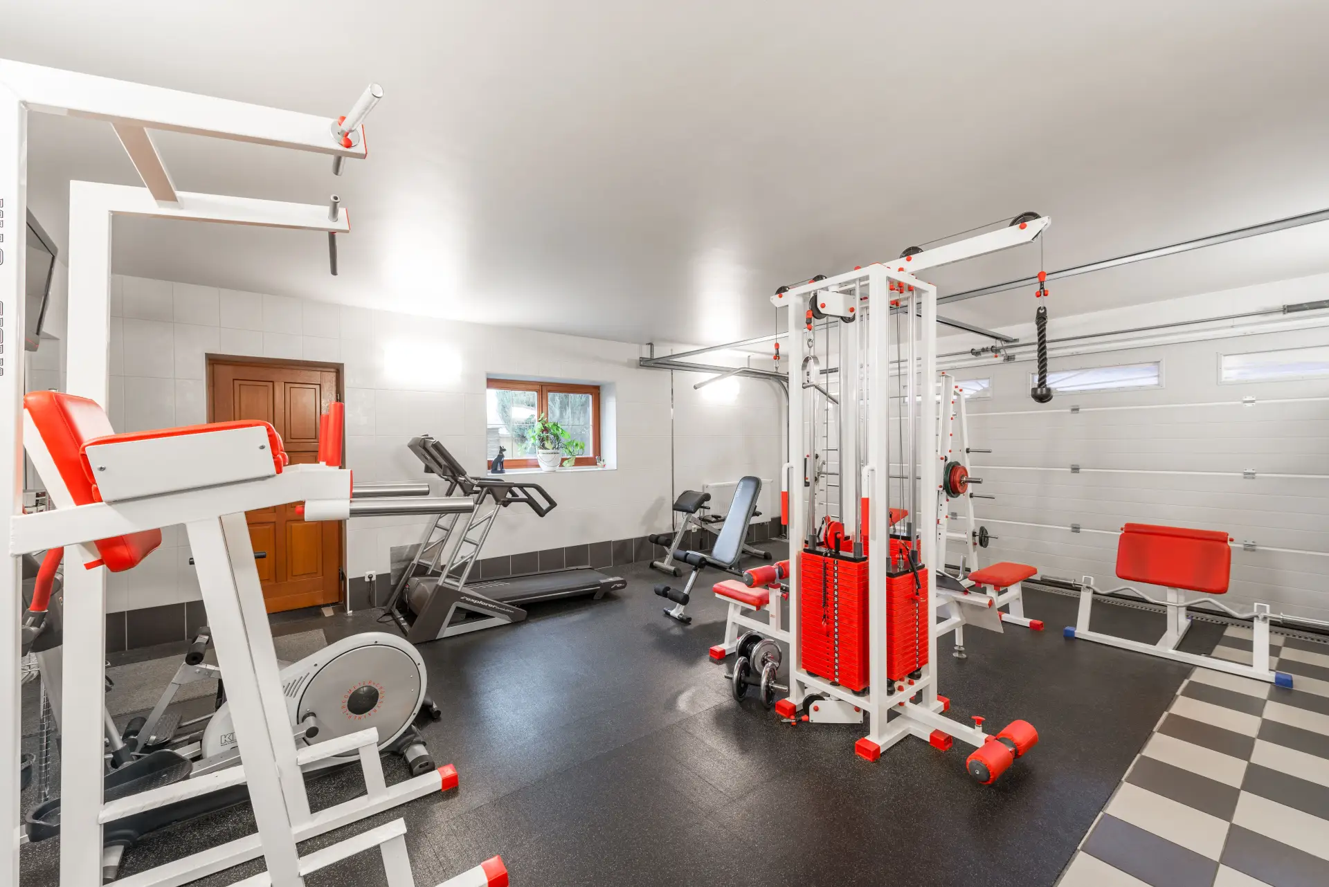 Finished basement home gym with a checkered hard floor