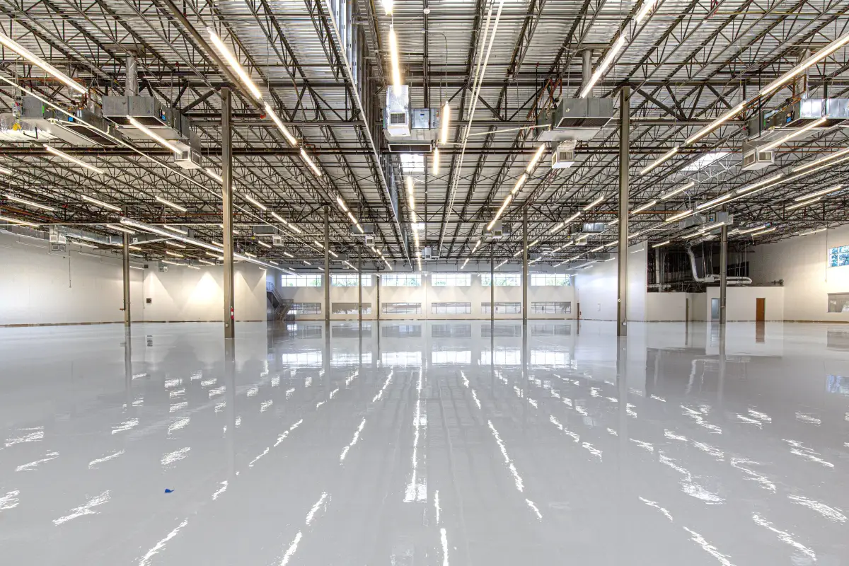 Glossy polished commercial concrete floor with steel truss ceiling