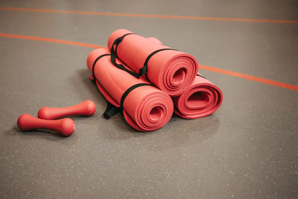 Gym floor detail with mats and dumbbells